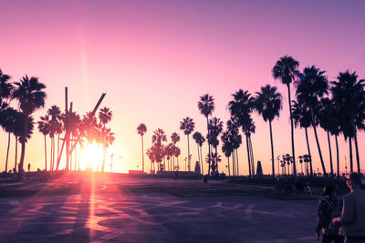 Silhouette palm trees on beach against sky during sunset