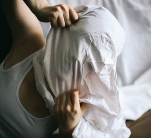 Close-up of woman with face covered in blanket at home