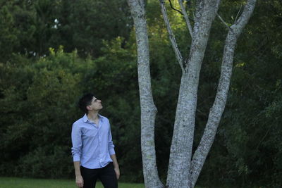 Full length of woman standing on tree trunk