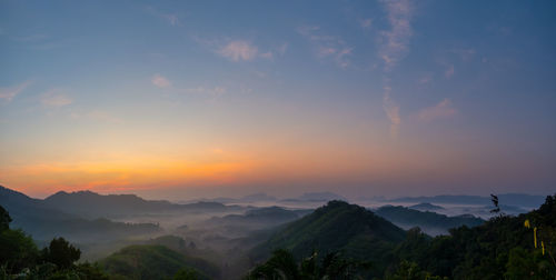 Scenic view of silhouette mountains against sky at sunset