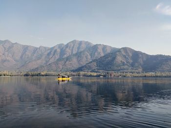 Scenic view of lake by mountains against sky