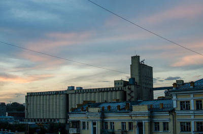 Low angle view of buildings against cloudy sky