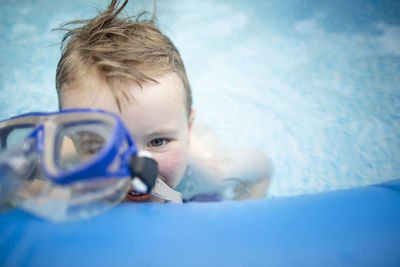 Young boy during summer swimming in swimming pool with goggles