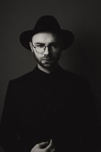 Portrait of young man standing against gray background