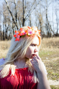 Beautiful woman with flower headband on hair during sunny day
