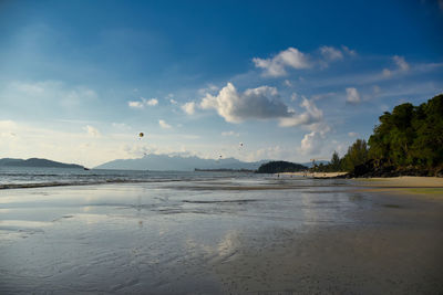 Waves of the azure andaman sea under the blue sky reaching the shores of cenang beach