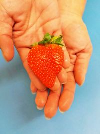 Close-up of hand holding strawberry