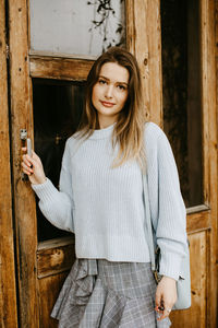 Portrait of woman standing by door