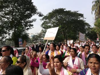 People standing on street against trees