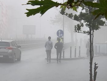 Rear view of people on street in city during winter