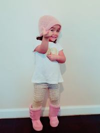 Full length of cute baby girl standing against wall