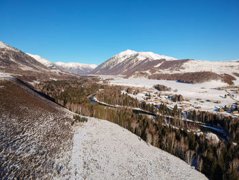 Scenic view of snowcapped mountains against clear blue sky