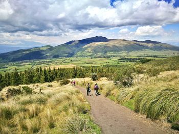 Hikers on road against mountains