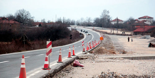 Road by built structures against clear sky