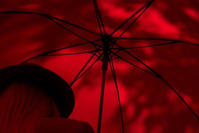 Low angle view of silhouette hand against red background