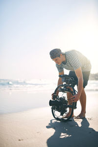 Rear view of man riding bicycle on beach