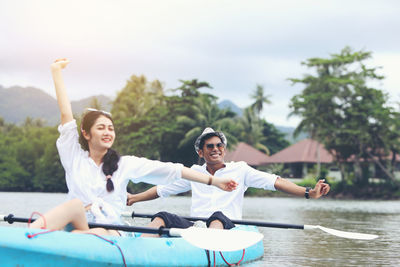 Friends enjoying in boat against sky