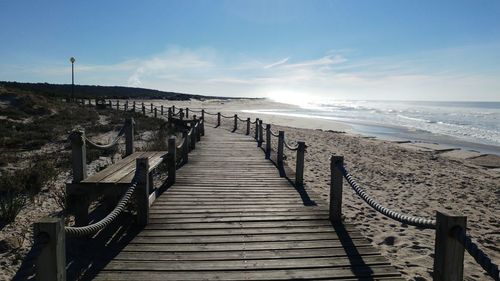 Boardwalk on beach against sky