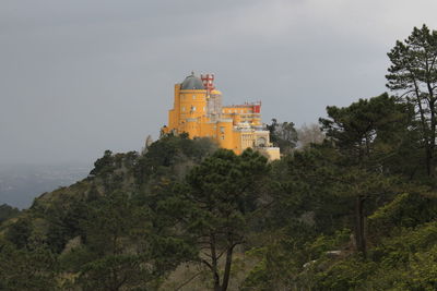 Castle by trees against sky