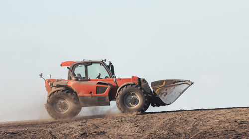 Tractor on field against clear sky