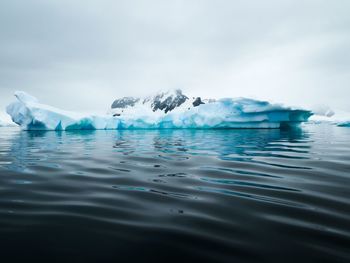 Sea and iceberg against mountain in antarctica