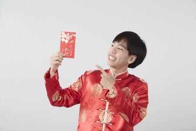 Smiling man holding umbrella against white background