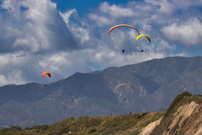 Low angle view of person paragliding against sky