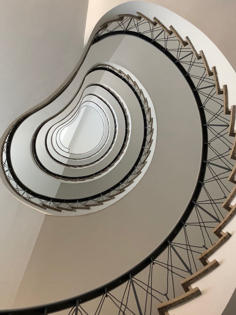 staircase, steps and staircases, architecture, spiral, built structure, railing, spiral staircase, low angle view, no people, pattern, indoors, design, directly below, shape, architectural feature, day, geometric shape, diminishing perspective, building, metal, ceiling