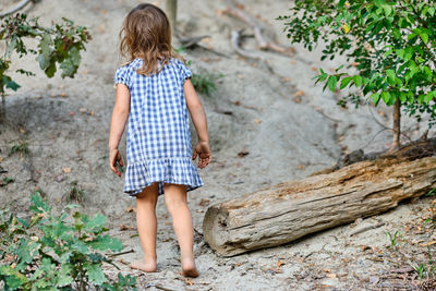 Rear view of girl standing on sand