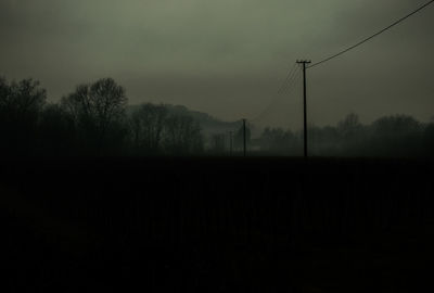 Silhouette trees on field against sky