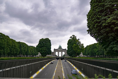 Road amidst trees against sky