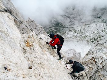 High angle view of friends rock climbing