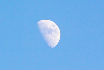 Low angle view of moon against blue sky