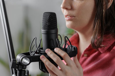 Midsection of woman holding microphone