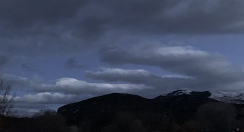 Scenic view of mountains against cloudy sky