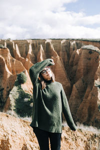 Woman standing on rock against sky