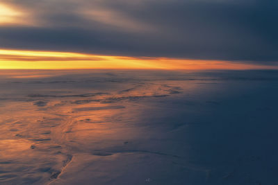 Scenic view of sea against dramatic sky during sunset