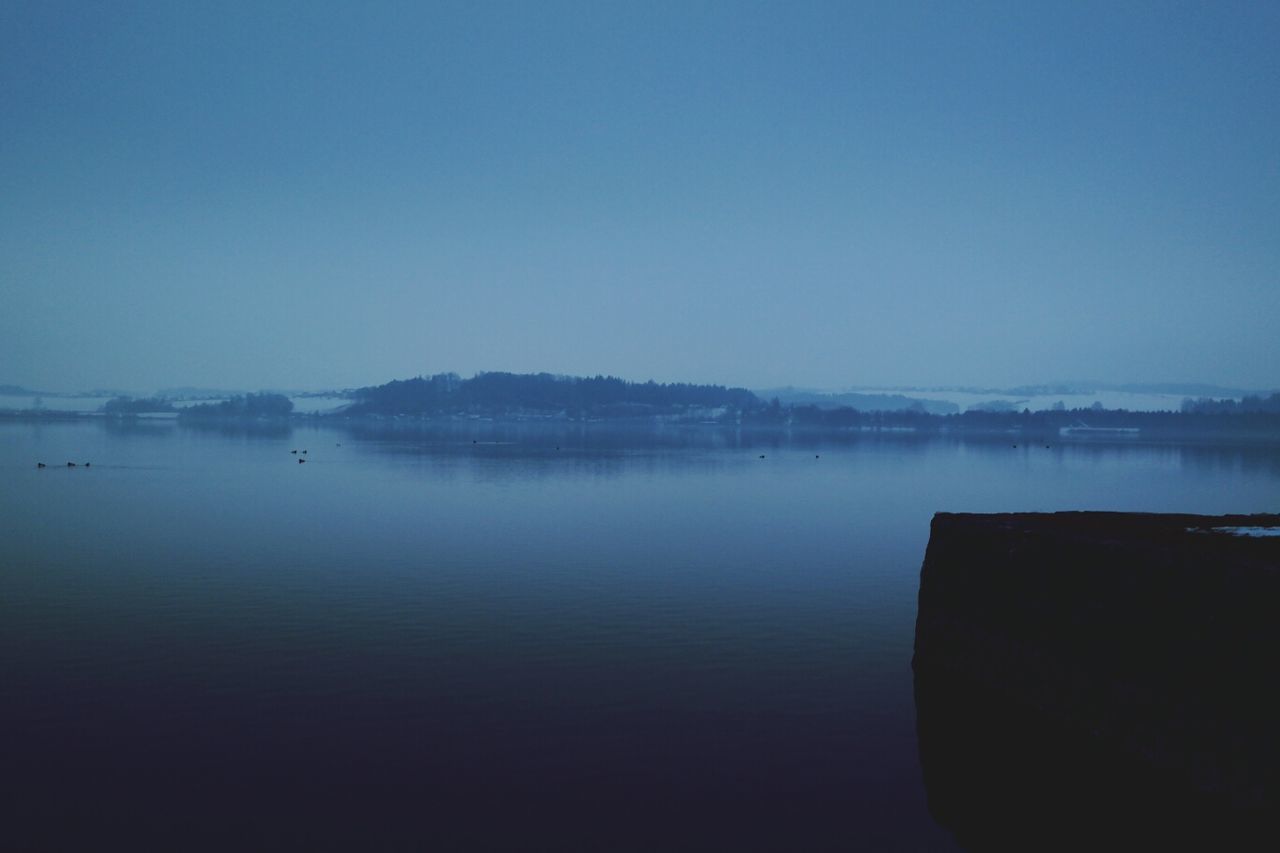 water, copy space, clear sky, waterfront, tranquil scene, tranquility, scenics, lake, beauty in nature, blue, nature, sea, reflection, river, calm, idyllic, nautical vessel, outdoors, built structure, no people