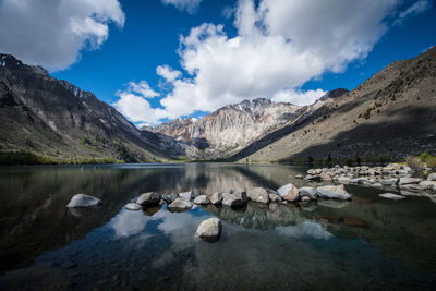 Scenic view of lake by mountains against sky