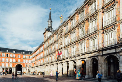 People on street amidst buildings in city