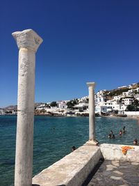 Columns by sea against clear blue sky at mykonos