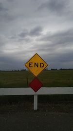 Close-up of road sign against sky