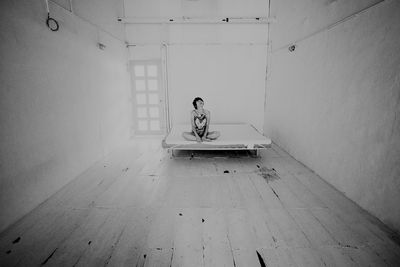 View of woman on bed in empty room