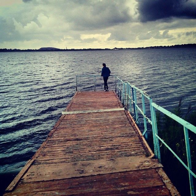 water, sky, pier, the way forward, rear view, full length, tranquility, tranquil scene, wood - material, sea, railing, jetty, cloud - sky, standing, men, lifestyles, nature, boardwalk