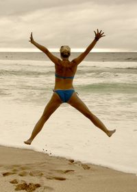 Full length of woman jumping on beach