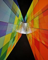 Low angle view of multi colored umbrellas against black background