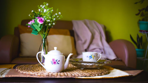 Tea pot, flowers, huge place mat, crystal tray and blanket in a living room 