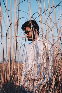 Young man standing amidst grass