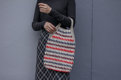 Midsection of woman standing against wall