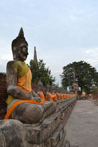 Statue against temple against sky